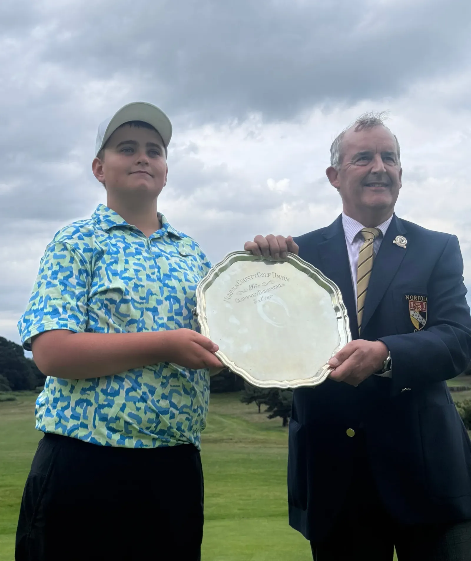 Norfolk Handicap Championship winner Jack Johnson receives the Geoffrey Burroughs Salver from Norfolk County Golf Union president Stuart Goodman
